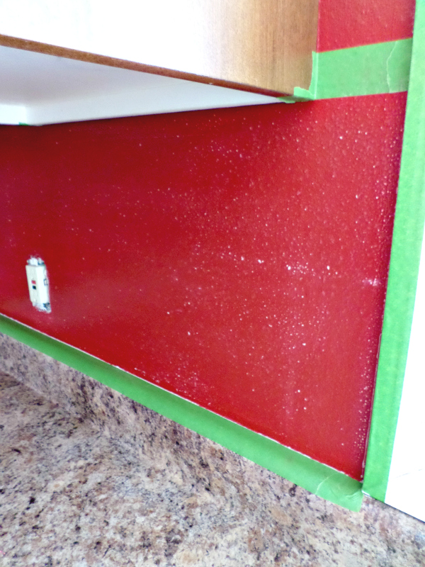 Taping off backsplash and sanding for paint.