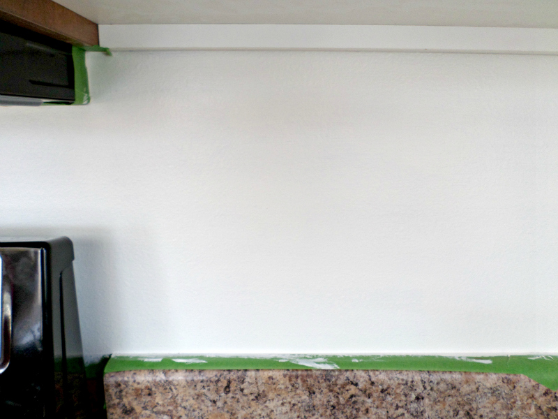 Paint underneath your cabinets to give your kitchen a faux tile back splash