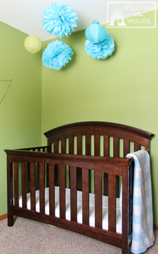 Simple crib with no bedding is that safest way to go for your baby! I love the hanging mobile tissue paper poofs over crib!