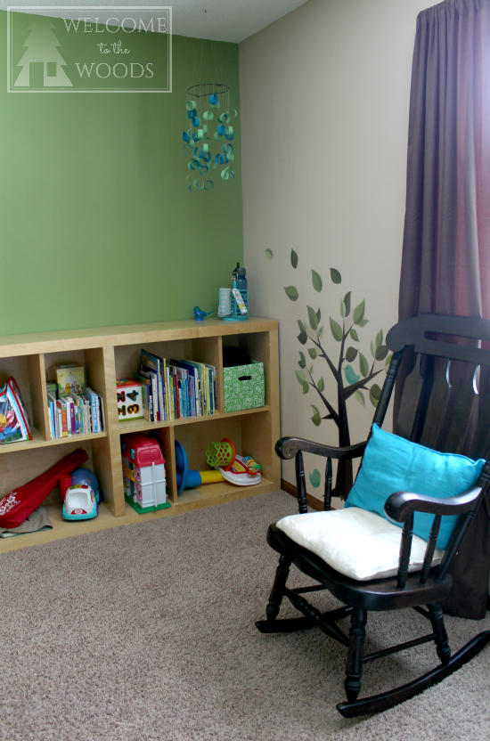 Rocking chair and bookshelf in a room designed for small child.