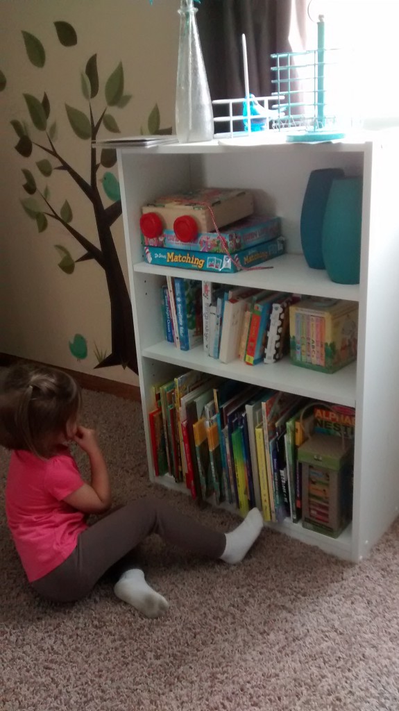 child reading by bookshelf