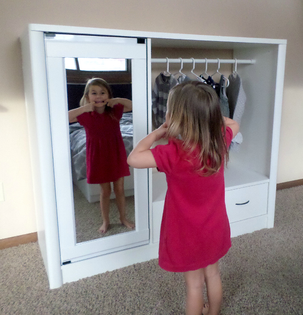 Little girl making silly face in mirror