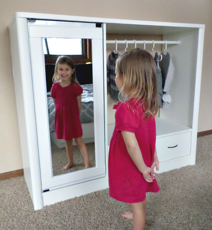 Little girl smiling at self in mirror