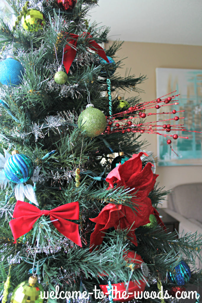 Christmas Tree Decor detail with pretty red poinsettias, glittery branches, and bows.