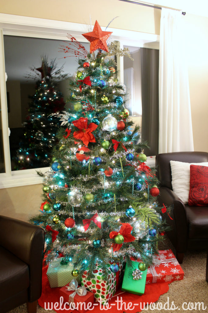 Tree lit up at night time with Christmas lights and decorations galore!