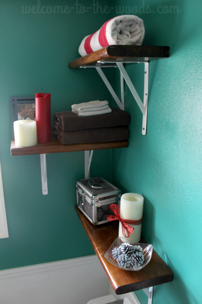 Decorations for Christmas on the shelves. Candles, pine cones, and rolled towels.