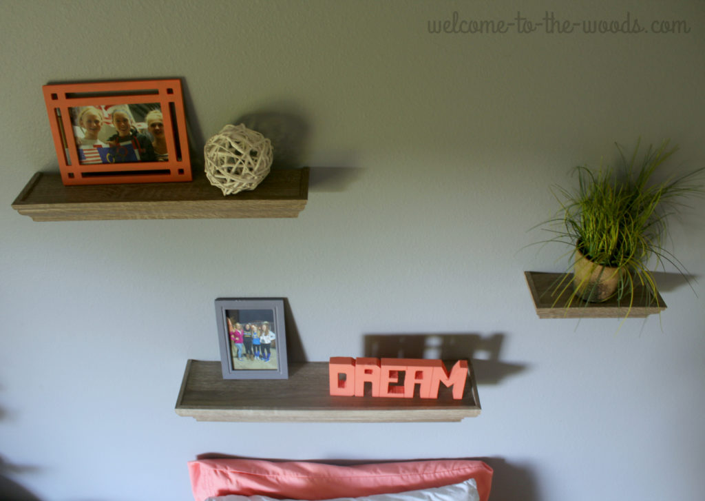 Shelving arrangement above bed in teenage girls bedroom design